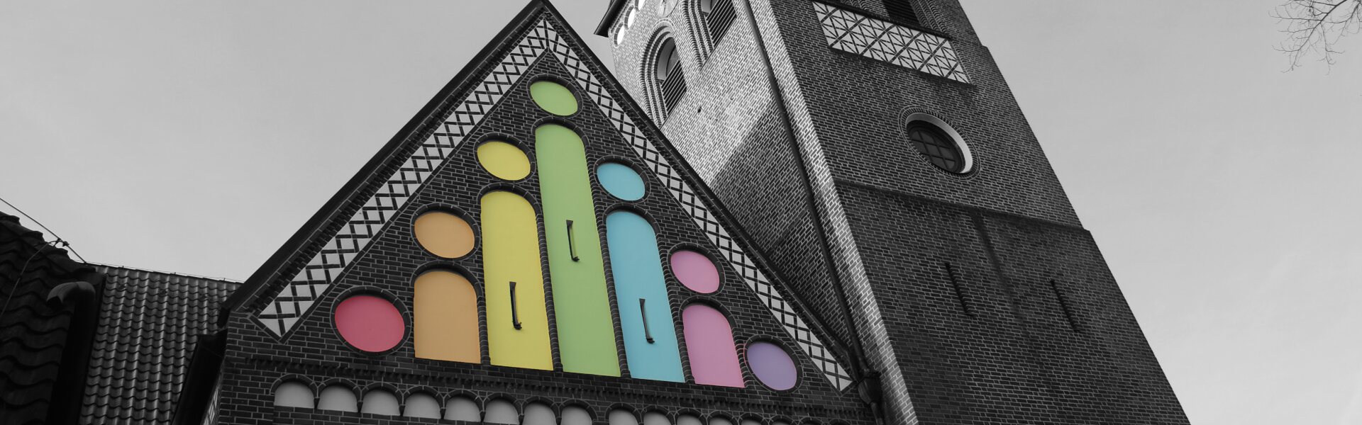 Nordseite der Michaeliskirche als Schwarzweiß-Bild, die Arcaden sind bunt eingefärbt wie das Logo.